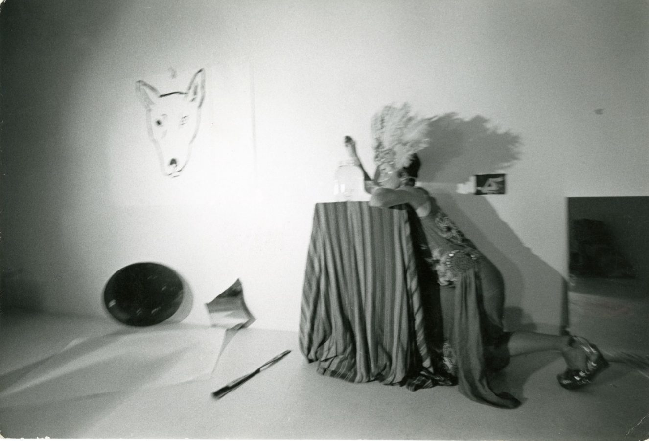 Jonas wearing a mask and feather headdress next to a drawing of a dog’s head