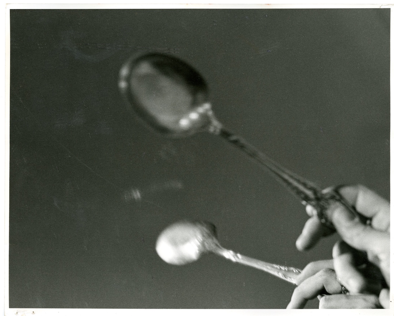 Photograph of a performer’s hand tapping a spoon against a mirror