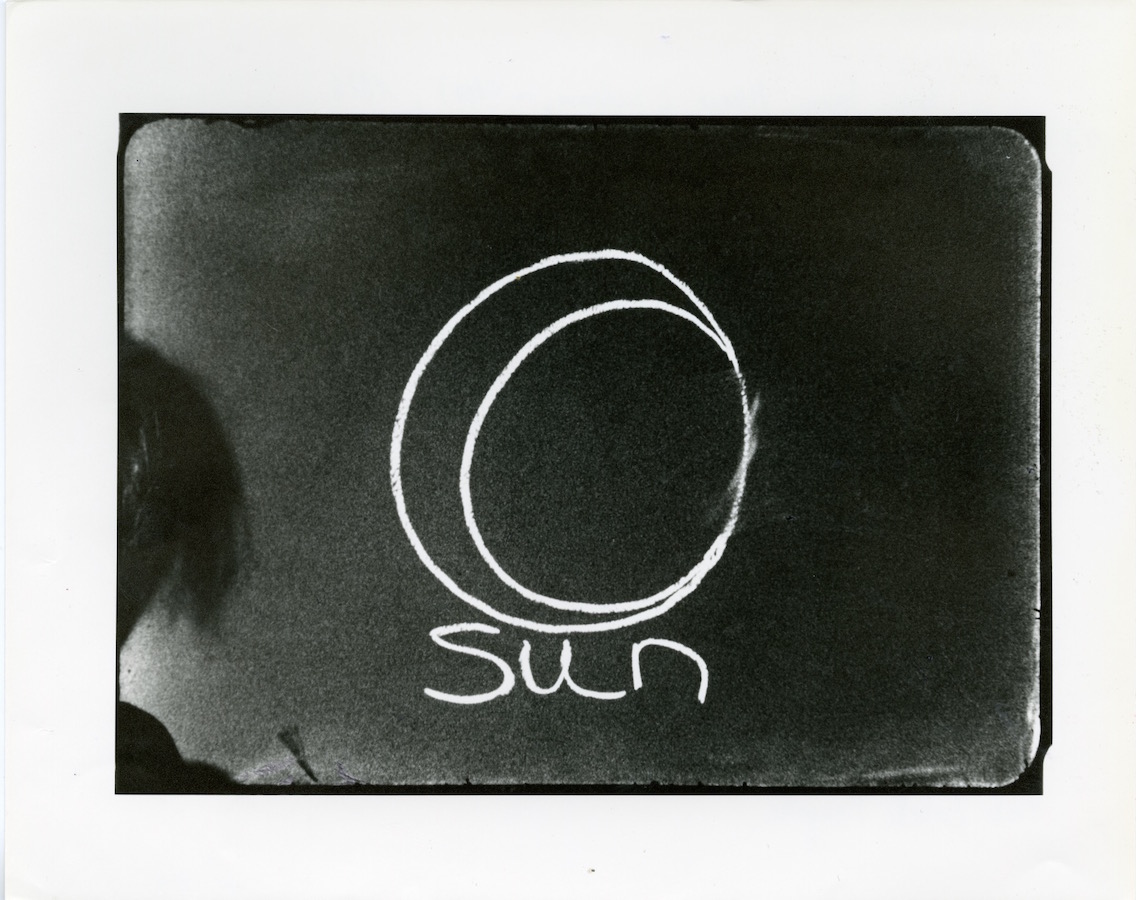 Chalk line drawing with the word “Sun”