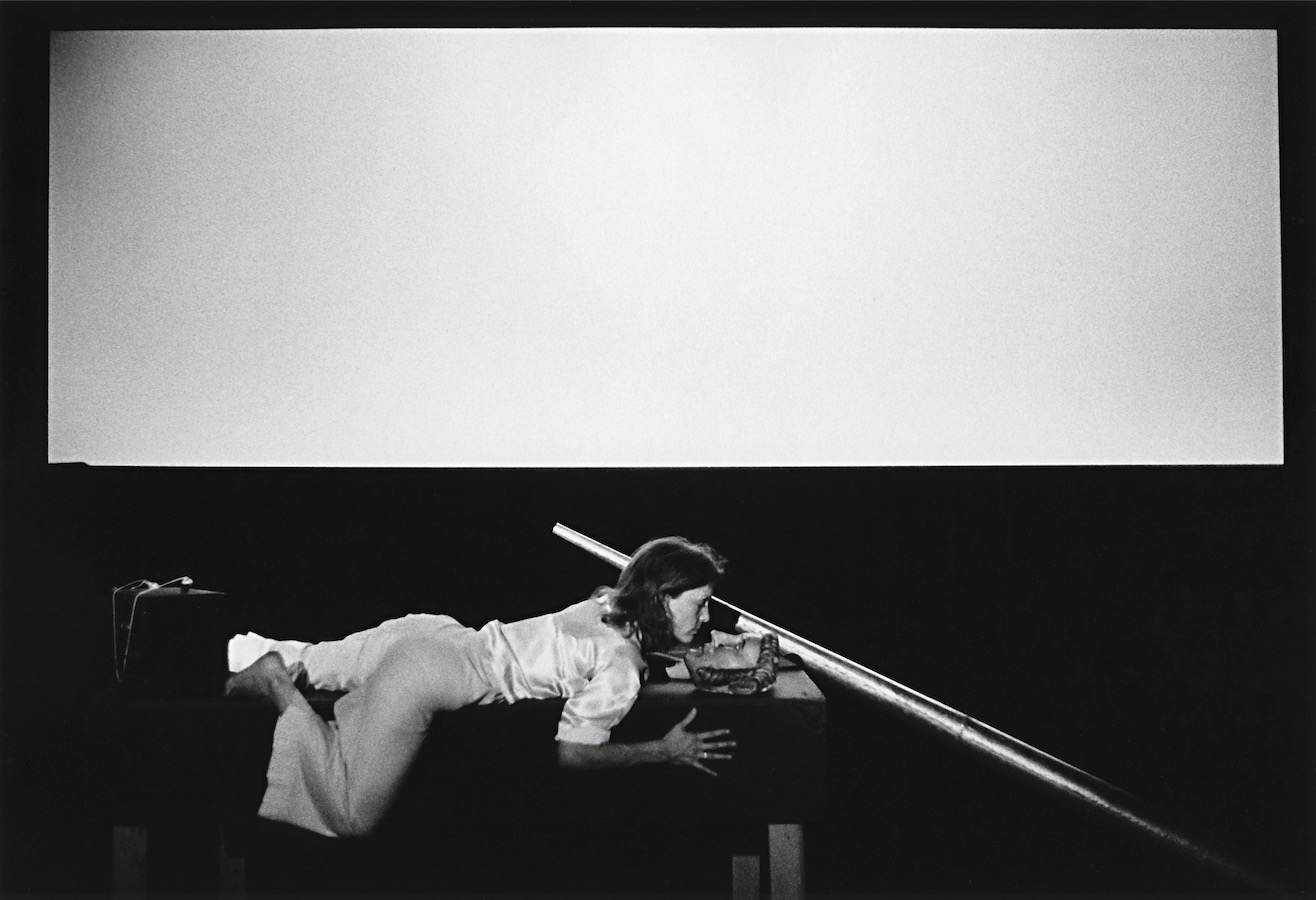 Jonas sprawled on top of a stage holding a large cone.