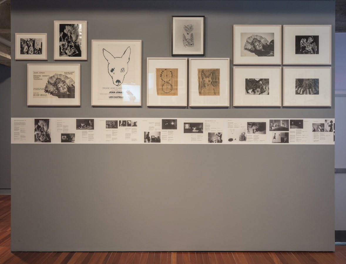 Various drawings, scripts, and photographs from Jonas’s performances are displayed on a wall.