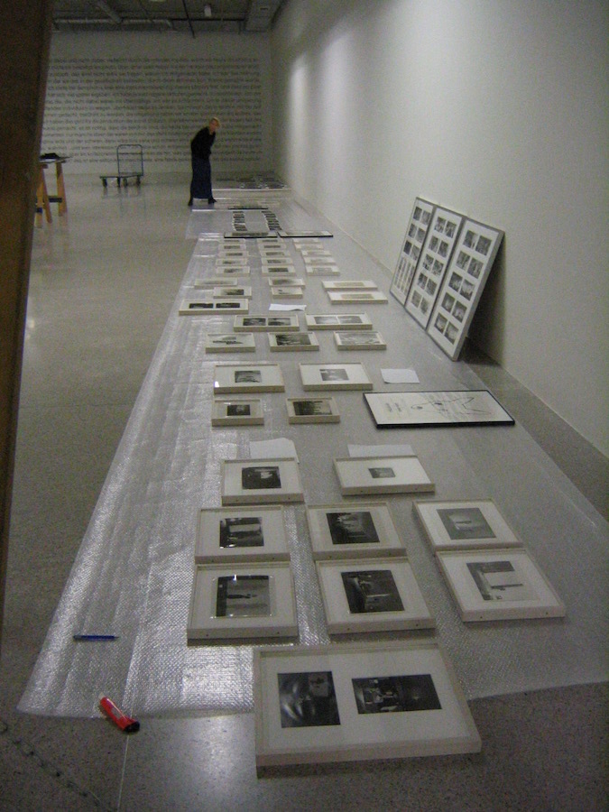 Framed photographs and drawings from Jonas’s performances are laid out on the floor on top of bubble wrap.