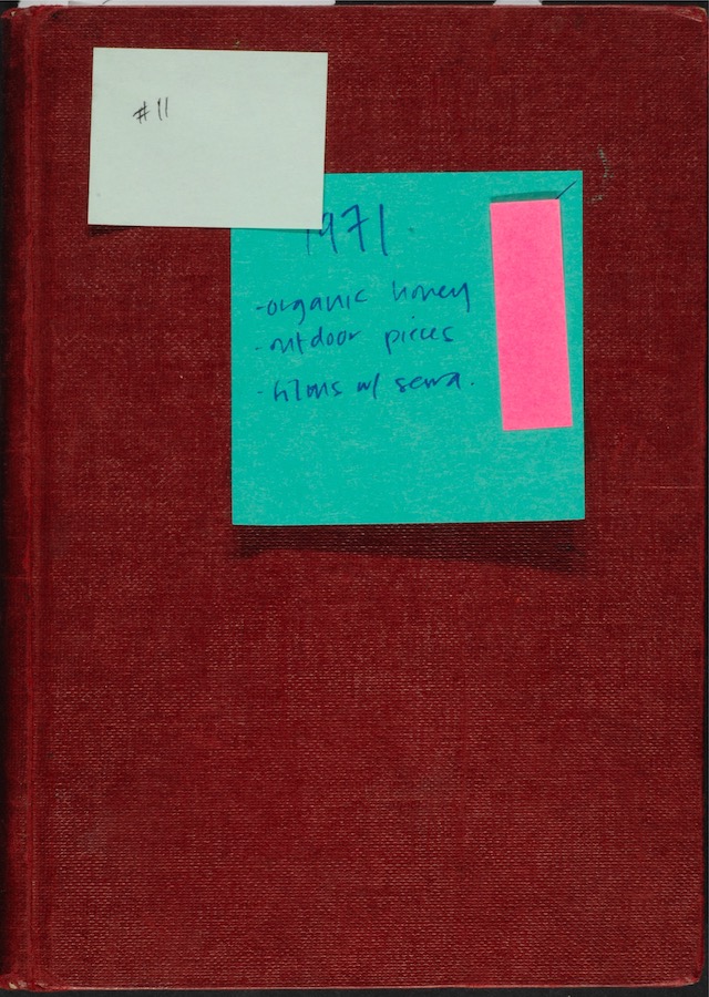 Cover of a notebook with a yellow and green sticky note. Yellow sticky note reads: “#11.” Blue sticky note reads: “1971 organic honey, outdoor pieces, films w/ Serra.”