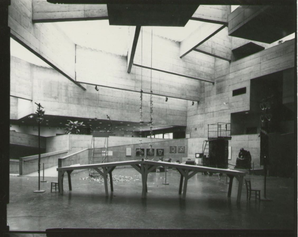 A swing hangs from the ceiling over a bridge placed in the middle of a room surrounded by various props.