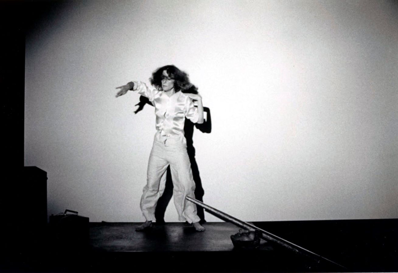 Jonas in motion on top of a table; a large metal cone, a mask, and a bag are also on the table.