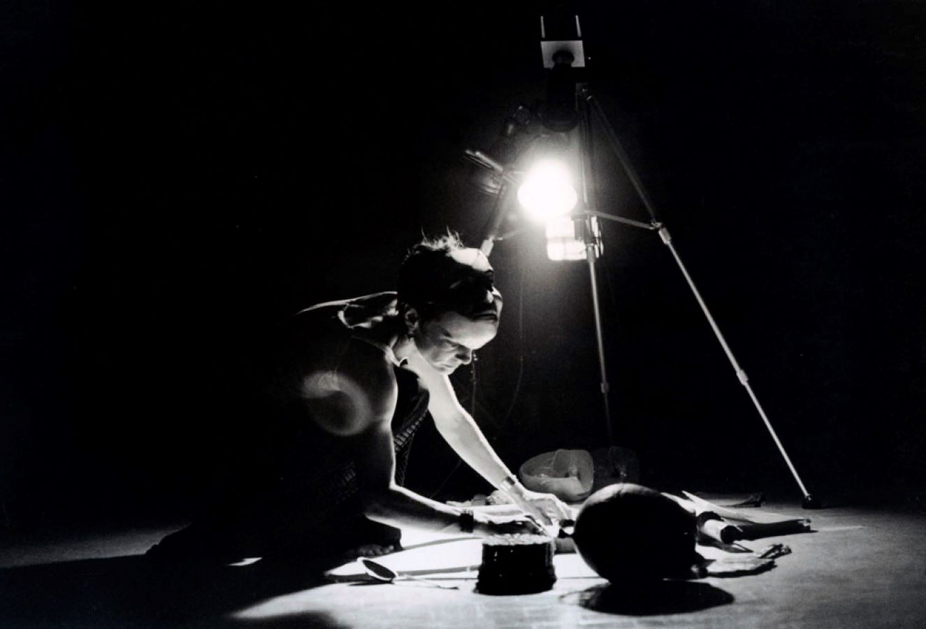 Jonas kneels below a camera and light on a tripod with various props