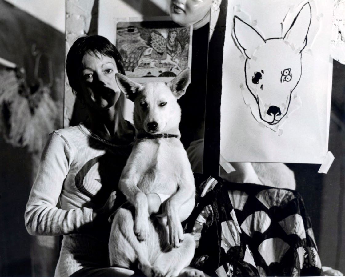 Jonas sitting next to a drawing of a dog’s head with a dog in her lap