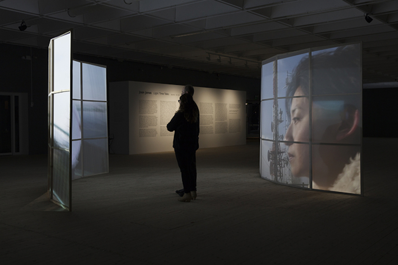 A figure stands in between two video projections on curved screens